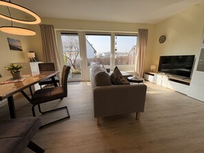Un salon moderne avec un canapé, une table à manger et un téléviseur.