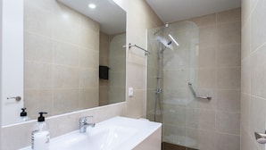 A modern bathroom with a large mirror, a white sink, a glass shower enclosure, and a toilet. - Modern Beachfront Escape, Calahonda (Mijas)