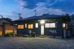 Ein Gebäude mit einem Schild, auf dem in japanischen Schriftzeichen 'Base in Hakone, um den Geist zu befreien' und 'SAKURAHOTEL' steht.