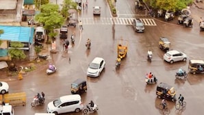 Une rue animée en milieu urbain, bordée d’immeubles, avec des véhicules et des piétons.