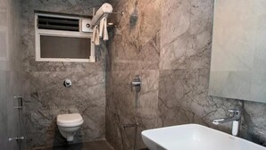 Une salle de bain avec des toilettes, une douche et un lavabo.