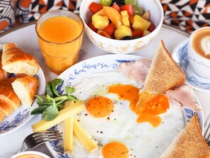 A breakfast plate with eggs, ham, cheese, toast, and a fruit bowl. - Mama Shelter Lake Como (Como)