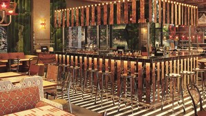 A bar area with a curved counter, multiple stools, and a patterned floor. - Mama Shelter Lake Como (Como)