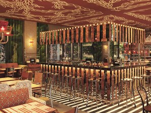 A bar area with a curved counter, multiple stools, and a patterned floor. - Mama Shelter Lake Como (Como)