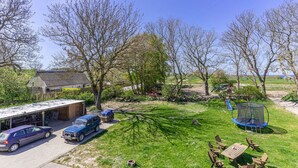 A residential property with a garage, parked cars, a trampoline, and a grassy yard. - Pferdehof Königsstuhl - Apartment 1 Mecklenburger - Holidays at the riding stable - (Lohme)