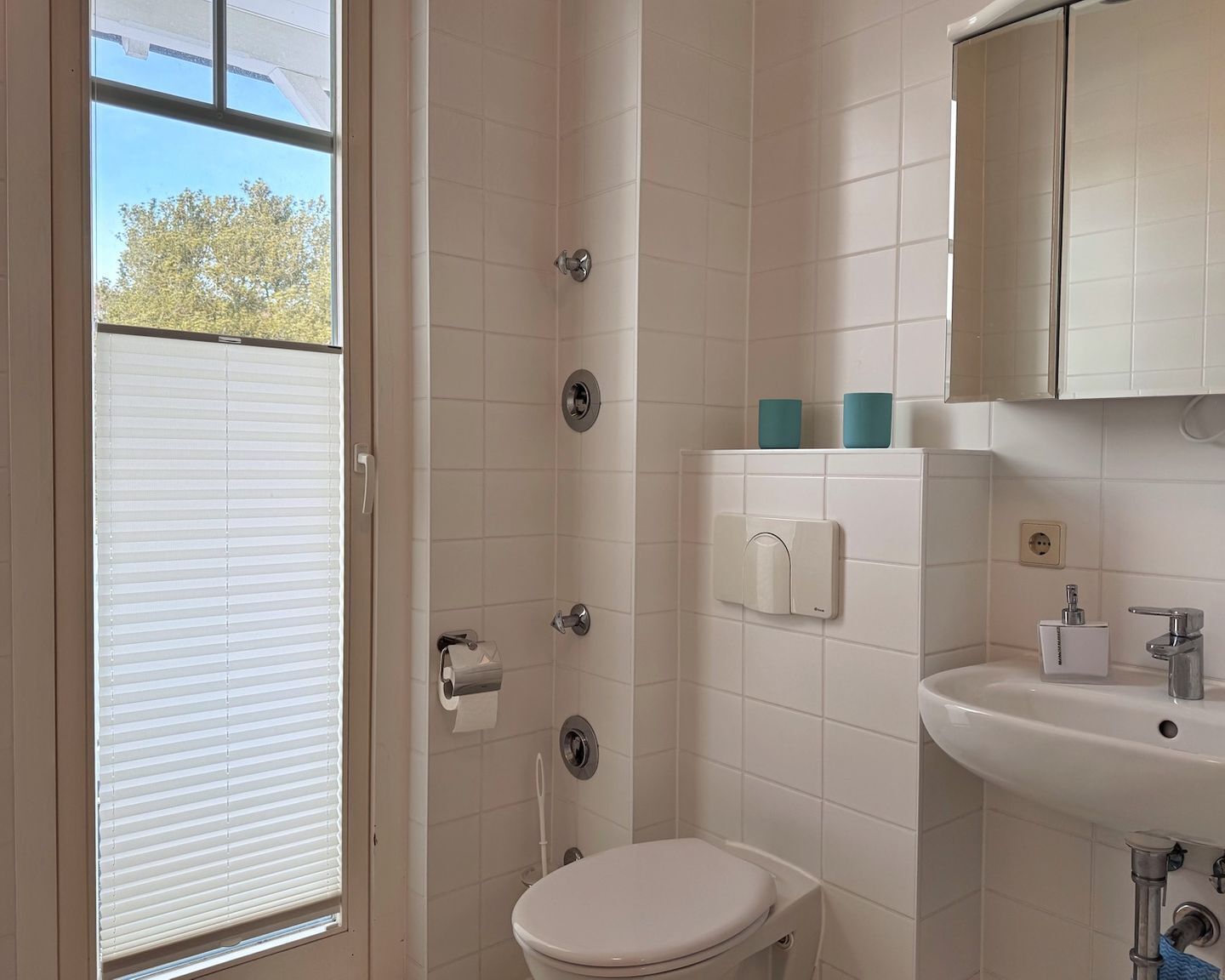 Une salle de bain avec des toilettes, un lavabo et une douche.