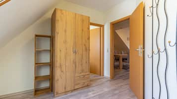 Une pièce avec une armoire en bois, une porte en bois et un porte-manteau.