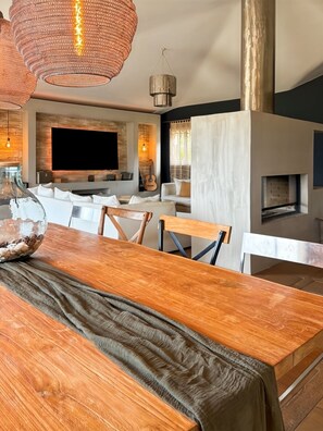 A modern living room with a large TV, wooden furniture, and a fireplace. - Large charming villa Porto-Vecchio swimming pool/poolhouse in private grounds (Porto-Vecchio)