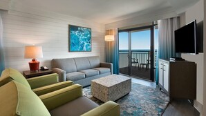 A hotel room with a sofa, armchairs, a TV, a lamp, and a view of the ocean. - Tropical Gateway: Oceanfront 3 Bdrm Condo 15th Flr (Myrtle Beach)