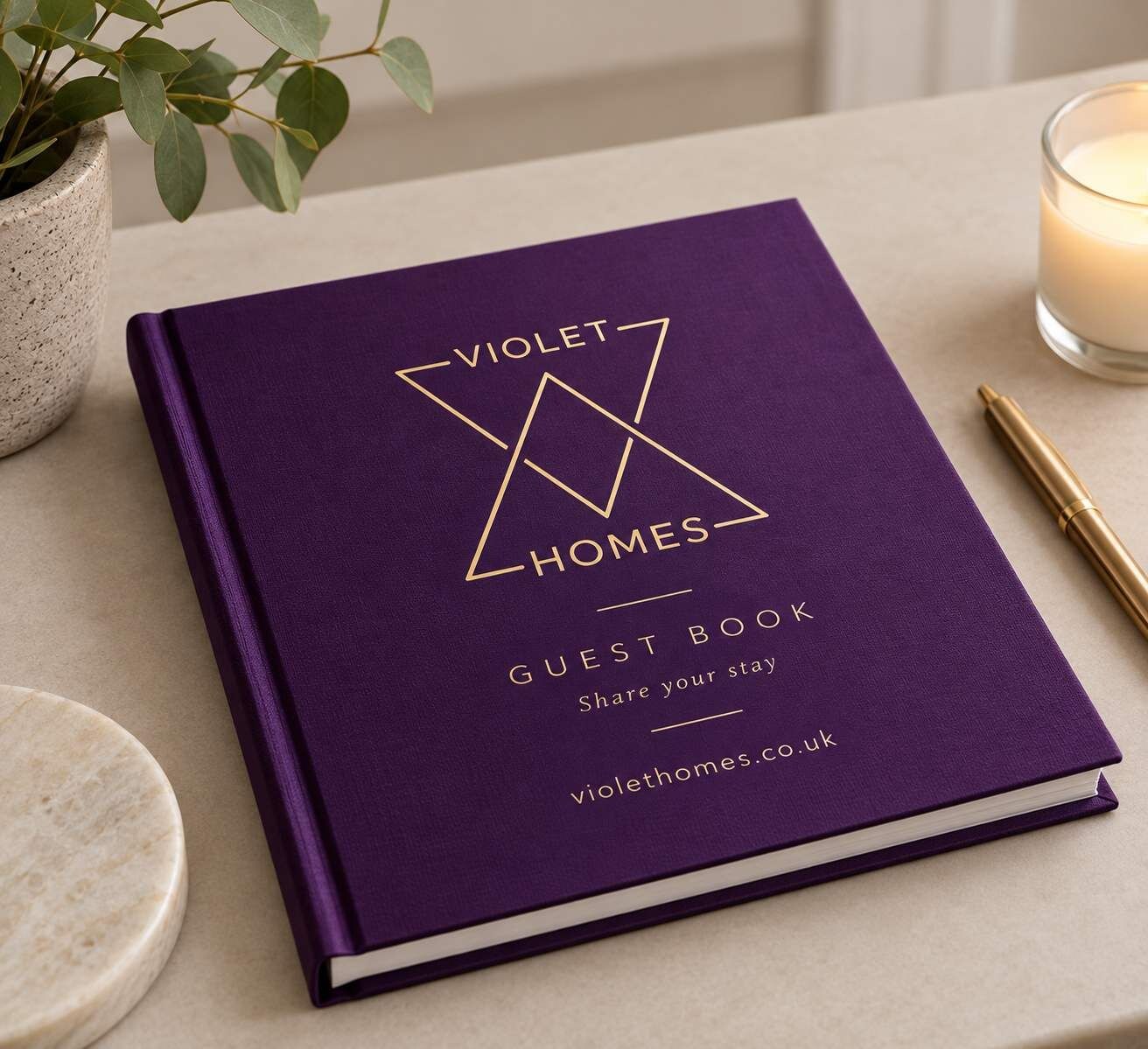 Ein violettes Gästebuch mit dem Titel 'Violet Homes' und einer Website-Adresse.