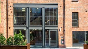 A brick building with large glass windows and a door. - The Botanical Suite - Luxury Apartment with Balcony & York Minster View (York)