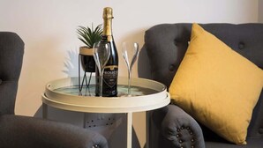 A room with a round table, a bottle of champagne, and two glasses. - The Aura Suite - Stylish Apartment Near York Minster Free Parking (Layerthorpe)