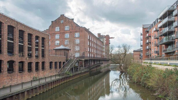 A canal with a brick building on one side and a modern apartment building on the other. - The Refinery Suite - Stylish York Apartment in Historic Building (York)