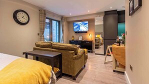 Une chambre d’hôtel avec un canapé, une télévision, un bureau et un lit.