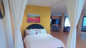 A bedroom with a bed, white curtains, a painting on the wall, and a television. - Your Private Escape with city views (Totara Park)
