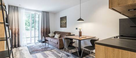 Una cocina moderna con comedor, sofá y un amplio ventanal.