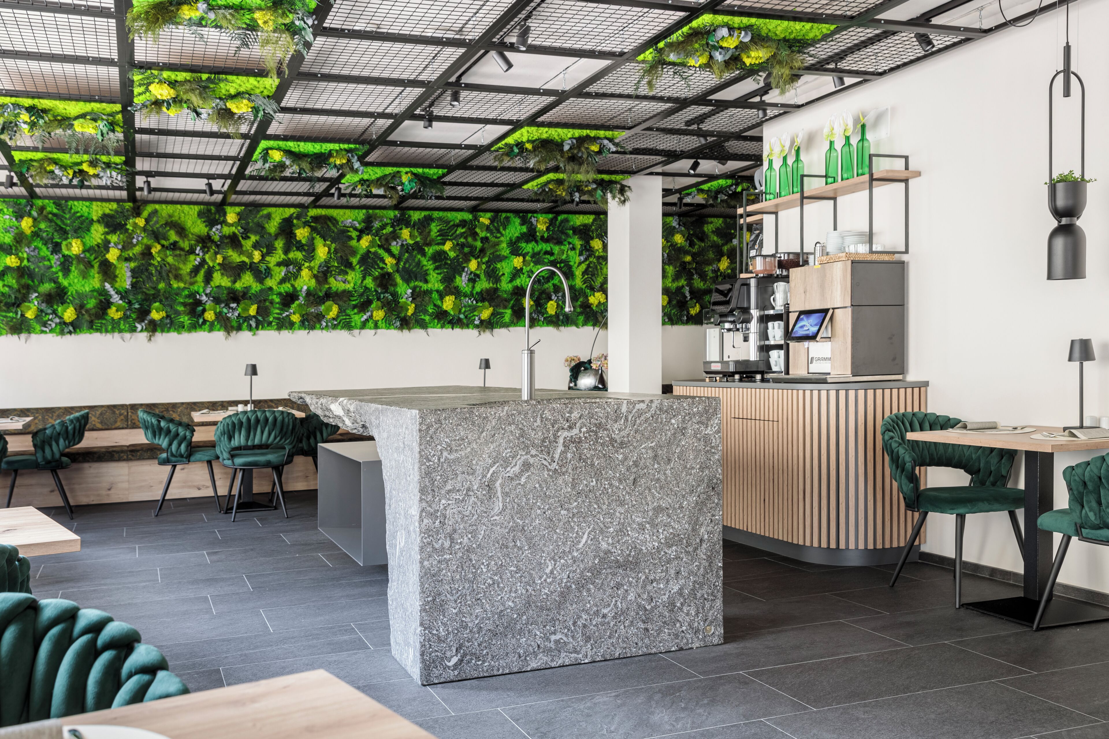 A modern interior with a green wall, a reception desk, and seating areas.