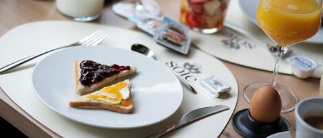 A breakfast setting with toast, a glass of orange juice, and a plate with jam and cheese.