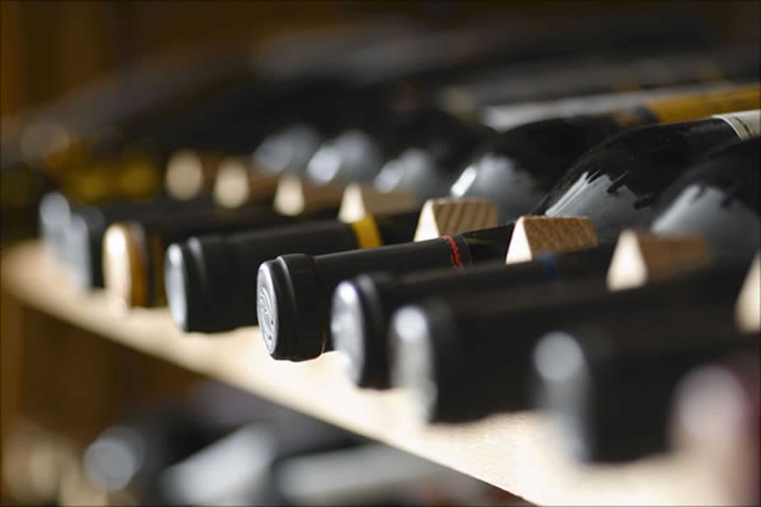 Una hilera de botellas de vino en una estantería.