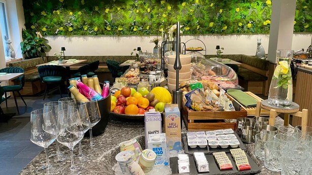 Ein reichhaltiges Frühstücksbuffet mit Speisen, Getränken und Milchprodukten.