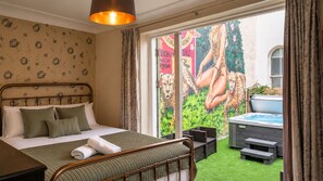 A bedroom with a bed, a hot tub, and a mural of leopards. - The Brighton Parlour with Hot Tub (Brighton)