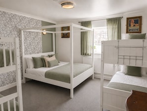 A room with a four-poster bed, bunk beds, patterned wallpaper, and a framed picture on the wall. - The Brighton Parlour with Hot Tub (Brighton)