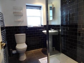 A bathroom with a toilet, sink, and a window. - The Brighton Parlour with Hot Tub (Brighton)