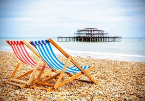 Two striped beach chairs on a pebbled beach with a pier in the background. - Central Cute Garden Cottage Close to Town & Beach (Brighton and Hove)