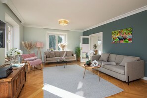 A living room with a sofa, a coffee table, a lamp, and a painting on the wall.