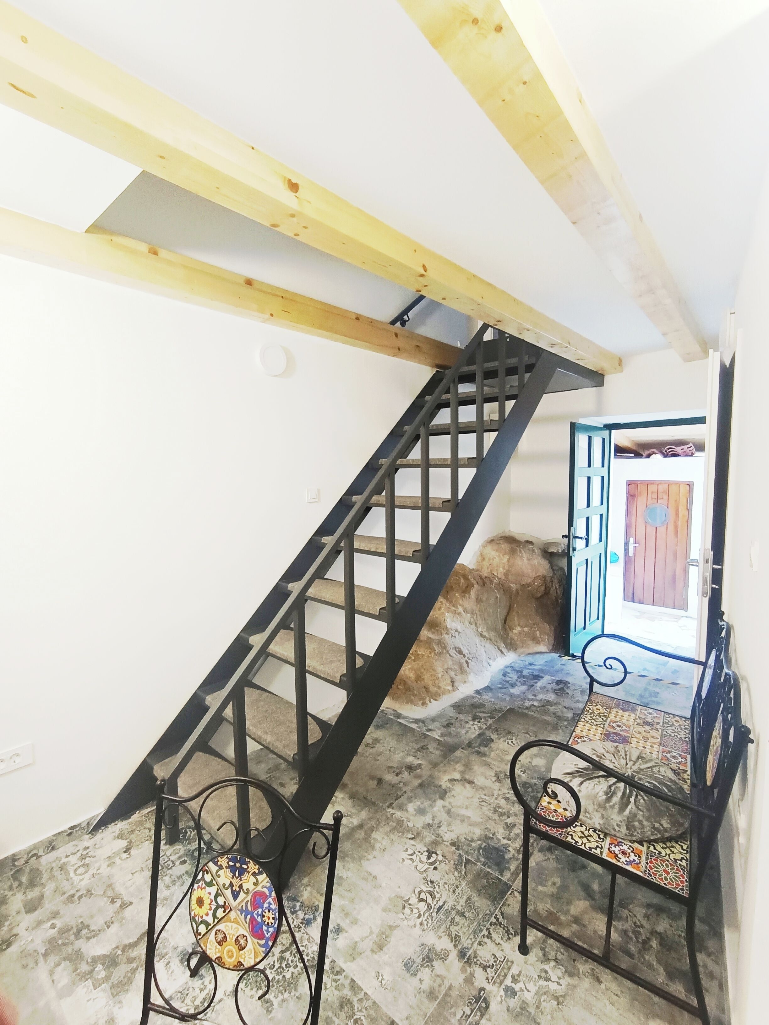 A staircase with black railings leading to a door with a blue frame.