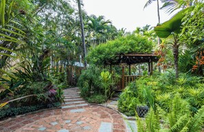 A garden pathway leading to a wooden pergola with lush tropical vegetation. - Staymaster Ashlesha 2BR Villa Jet Pool (Nerul)