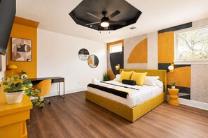Un dormitorio moderno con cama, escritorio y planta en maceta.