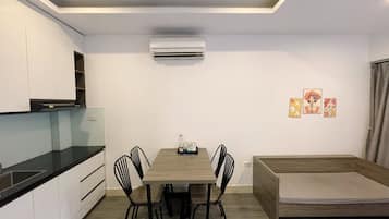 Uma cozinha compacta com mesa, cadeiras e um banco embutido.