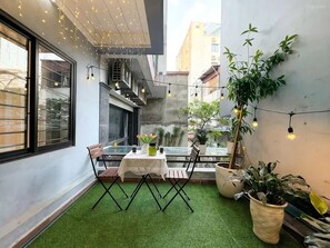 A small outdoor seating area with a table, chairs, and potted plants. - Biko Apartment (Hanoi)