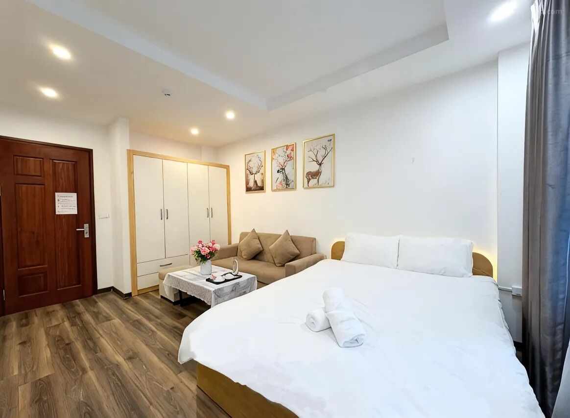 Une chambre d’hôtel comprenant un lit, un canapé, un bureau et une armoire.