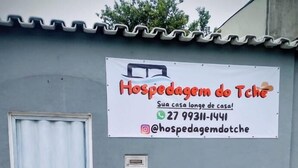 Letrero de 'Hospedagem do Tche' con información de contacto y un nombre de usuario de Instagram.