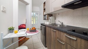 Une cuisine moderne équipée d’un lave-vaisselle encastré, d’un évier et d’un plan de travail sur lequel se trouve un grille-pain.