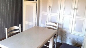 Zona pranzo con tavolo, sedie, forno a microonde e pensili.