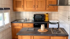 Una cucina con mobili in legno, un forno a microonde, una macchina per il caffè e un tostapane.