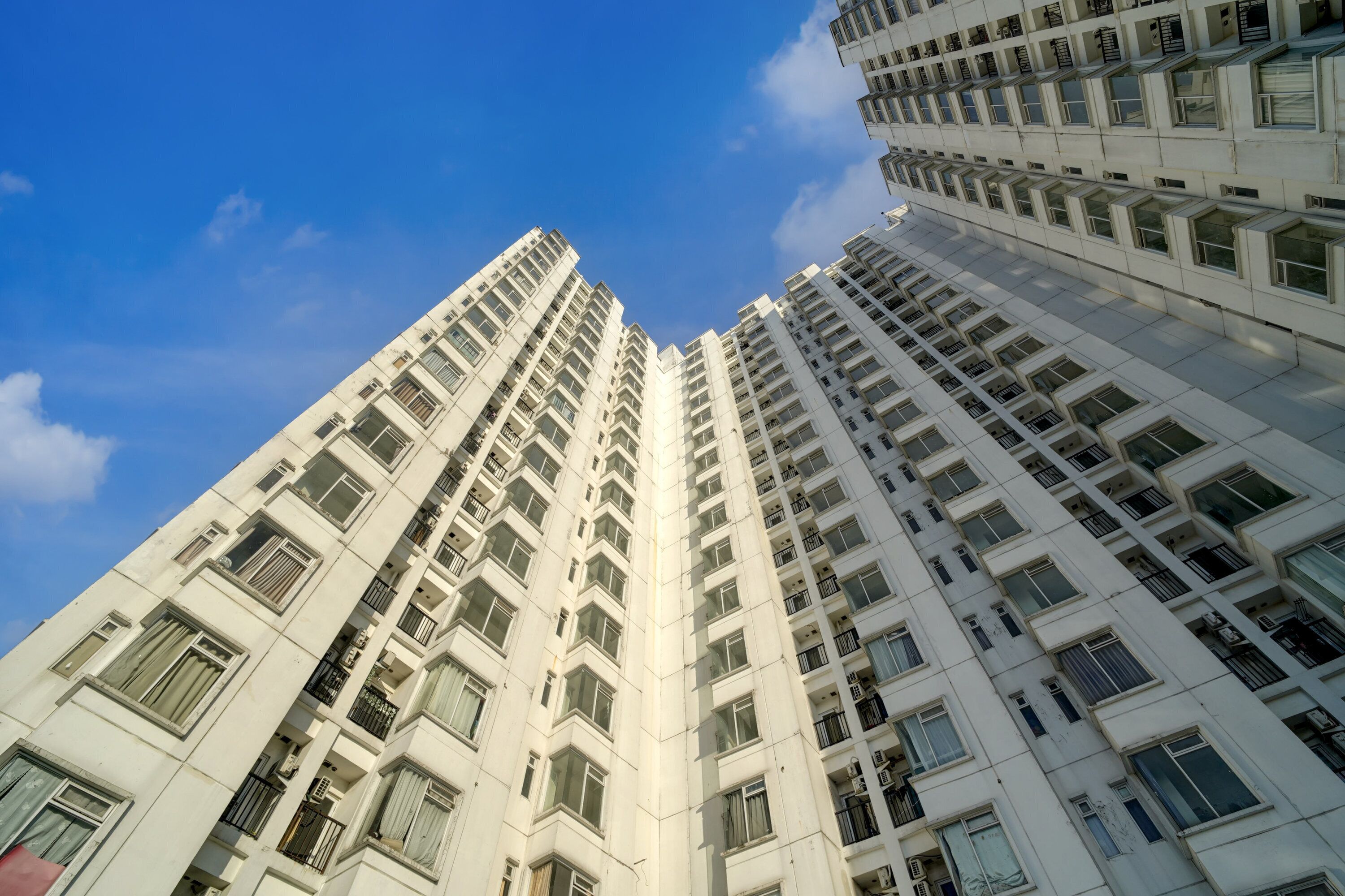 A high-rise building with multiple floors, large windows, and balconies.