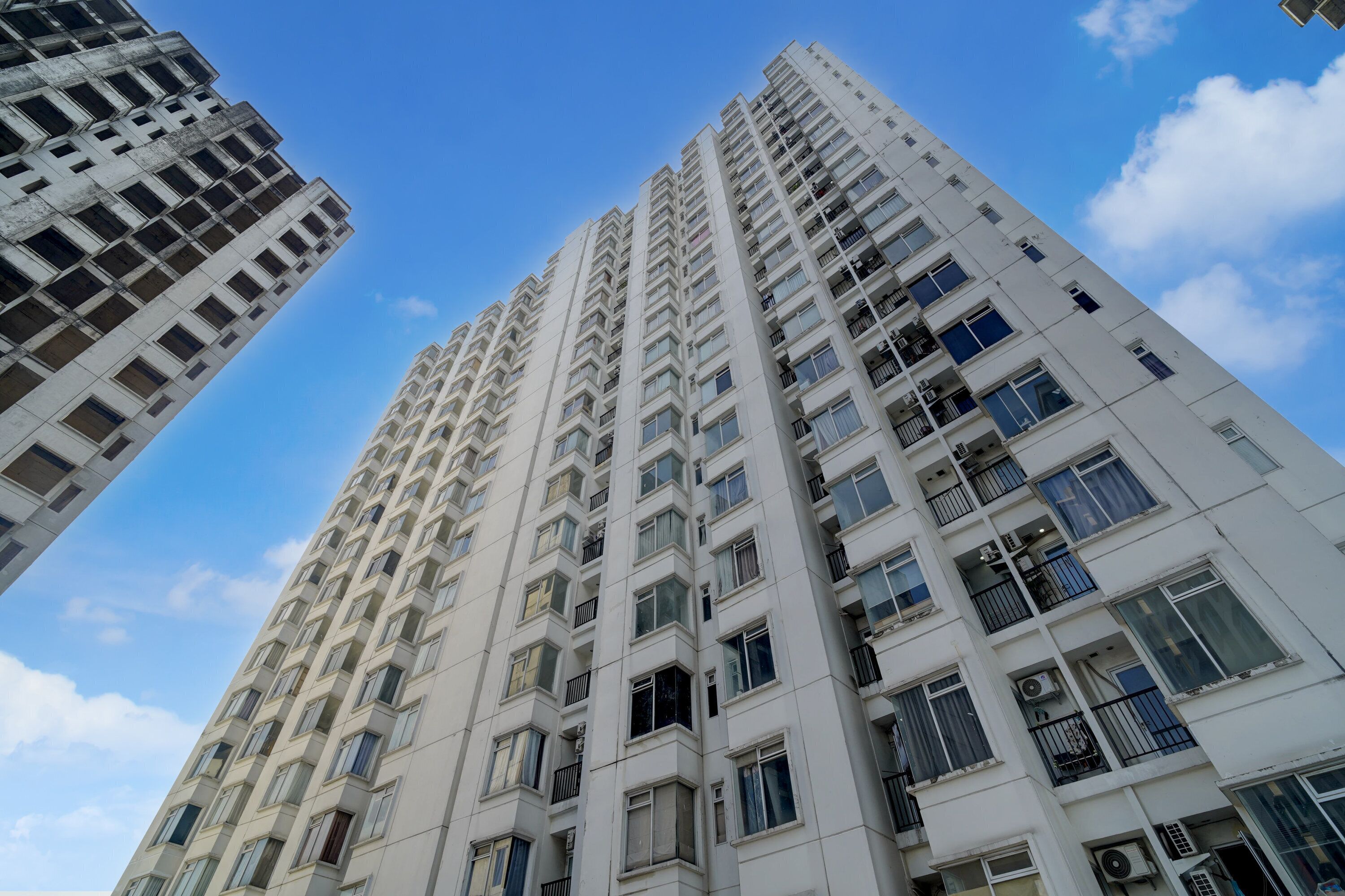 A high-rise building with multiple floors, large windows, and balconies.