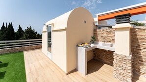 A modern outdoor kitchen with a stone wall, a built-in sink, and a curved overhead structure. - Apartment With Pool in the Heart of Marbella (Marbella)