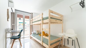A bunk bed with a desk and chair, a small table, and a high chair. - Apartment With Pool in the Heart of Marbella (Marbella)