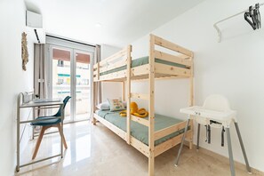 A bunk bed with a desk and chair, a small table, and a high chair. - Apartment With Pool in the Heart of Marbella (Marbella)