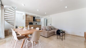 A modern interior with a dining area, a sofa, a staircase, and a kitchen. - Apartment With Pool in the Heart of Marbella (Marbella)