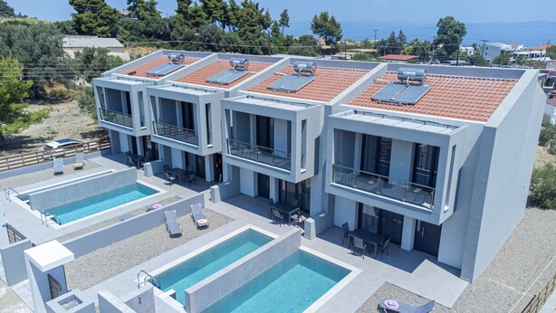 A modern hotel with multiple balconies, rooftop solar panels, and two swimming pools. - DaMa Maisonettes  by RentalsPro-Polychrono (Paliouri)