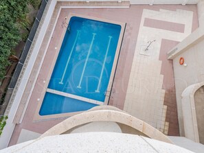 A swimming pool with a blue interior, surrounded by a tiled deck area. - Renovated apartment central Salou - 4 guests (Salou)