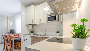 Una cocina moderna con microondas, lavamanos y plantas en macetas.