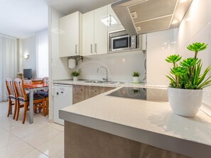 Eine moderne Küche mit Mikrowelle, Spüle und Topfpflanzen.