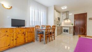 Una cocina moderna con comedor, televisor y un mueble de madera.
